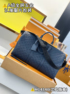 Dark blue embossed monogram duffel bag with top handle loop and wide strap