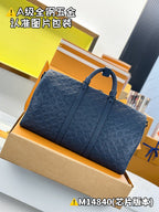 Dark blue embossed monogram duffel bag with dual handles, front zipper panel, strap