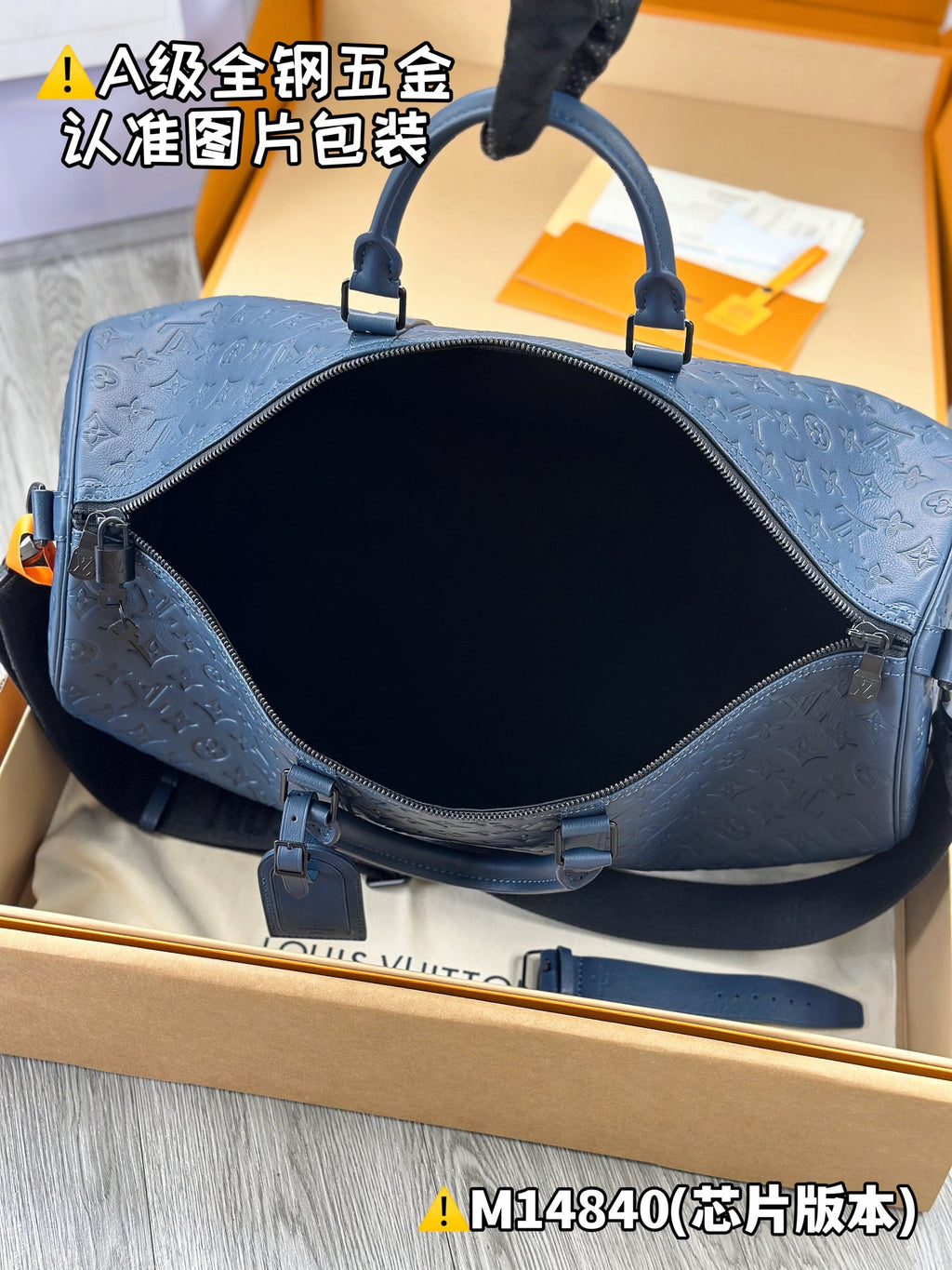 Dark blue embossed monogram duffel bag interior view with zip opening and straps