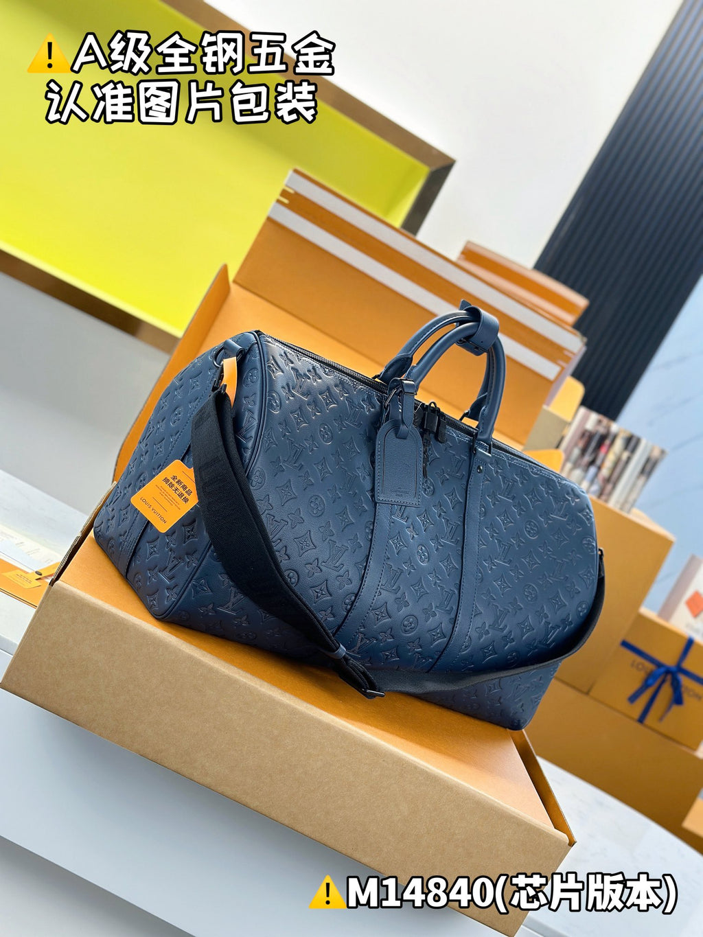 Blue embossed monogram duffel bag with top handles, side zipper pocket, and strap
