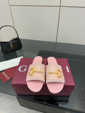 Light pink Gucci slide sandals with gold H-bit strap and open toe, on display box