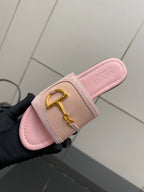 Light pink Gucci slide sandal with gold H-bit strap, footbed close-up