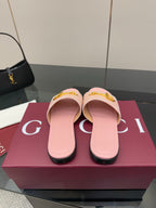 Light pink Gucci slide sandals with gold H-bit hardware, front view on display box
