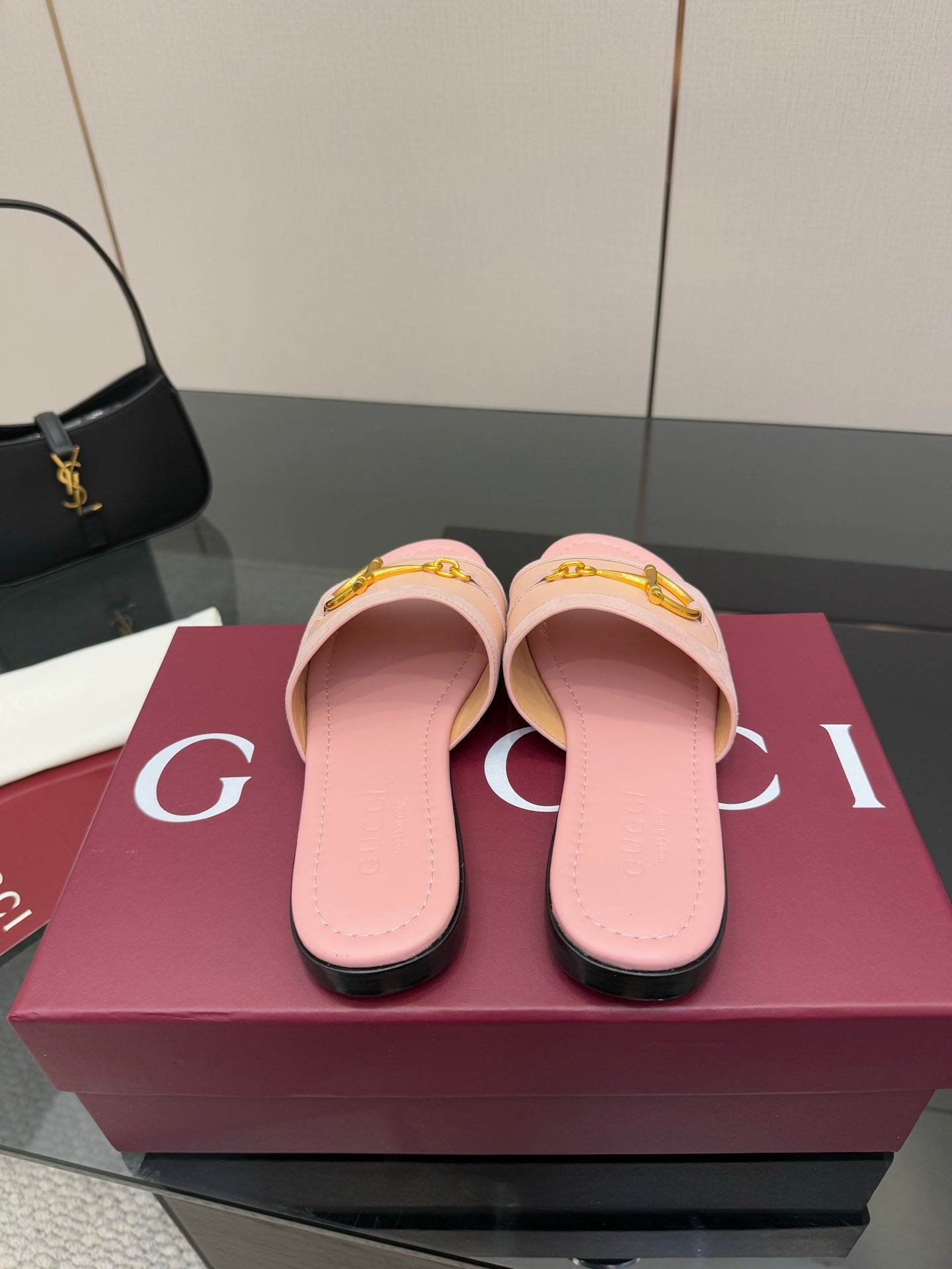 Light pink Gucci slide sandals with gold H-bit hardware, front view on display box