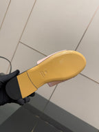 Yellow outsole of a light pink Gucci slide sandal, underside view