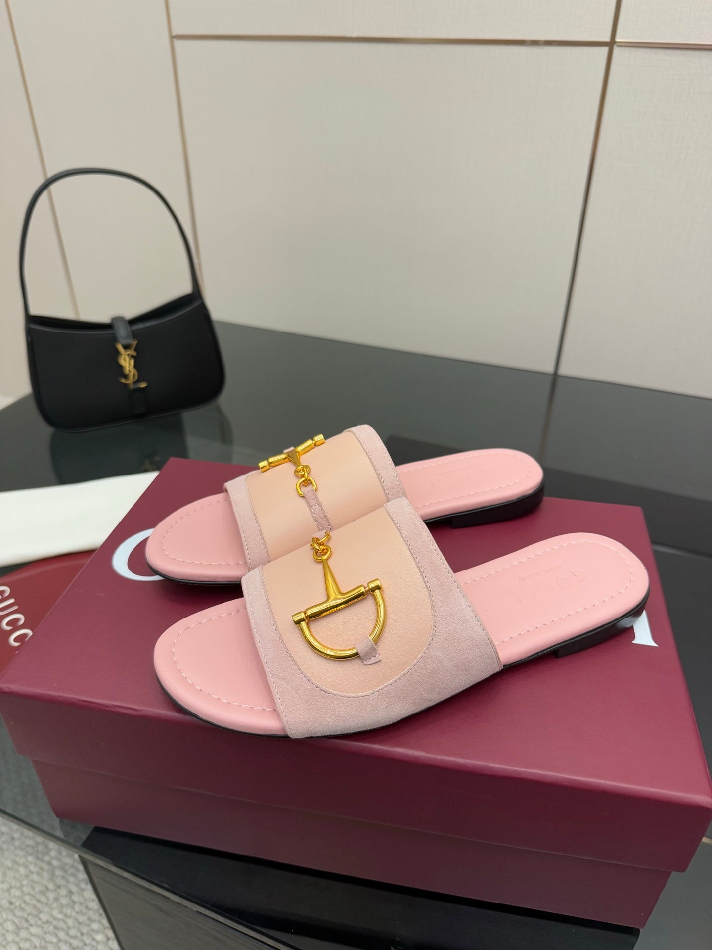 Light pink Gucci slide sandals with gold H-bit ornament on wide strap, top view