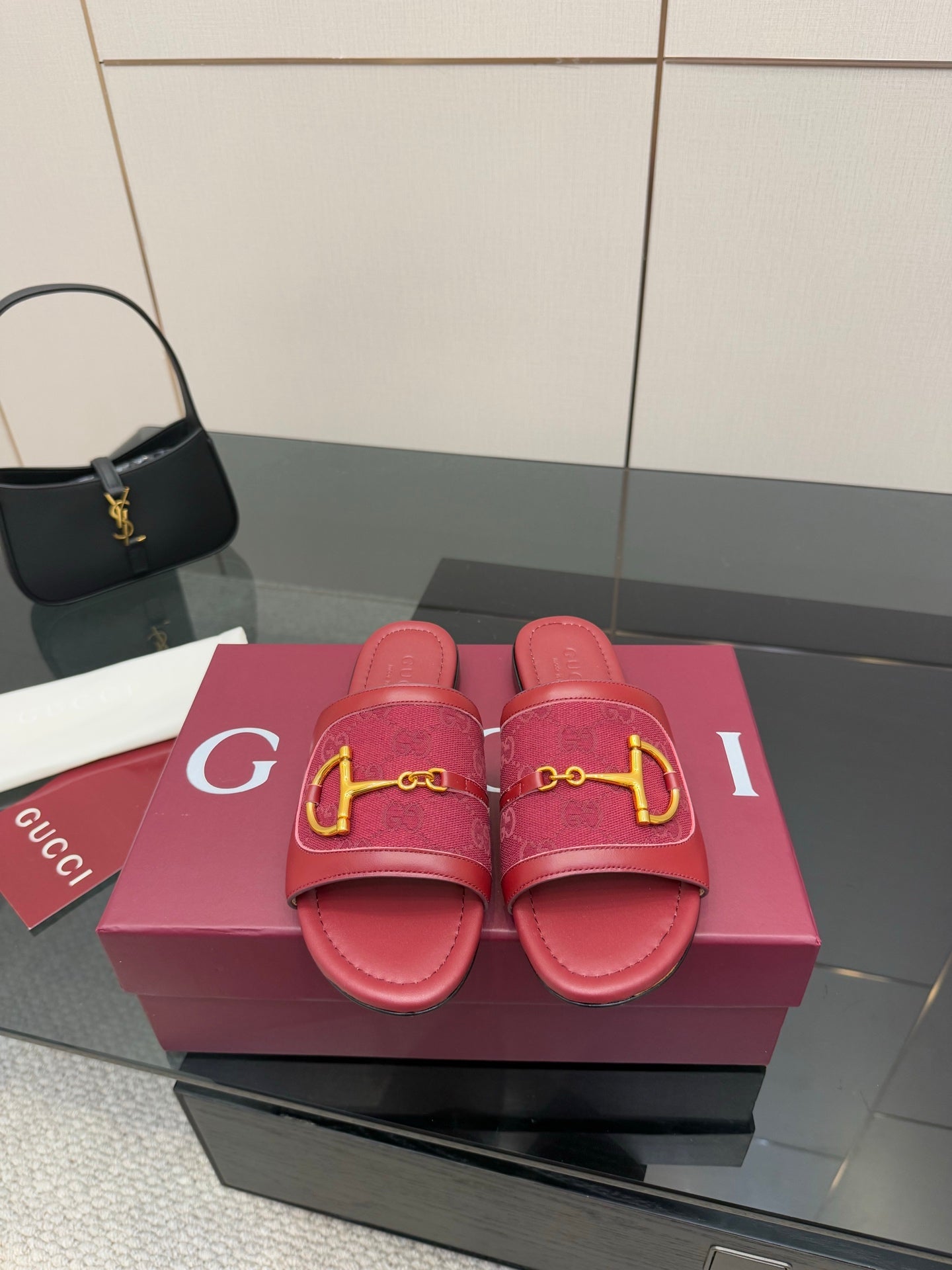 Women’s Gucci slide sandals in dark red leather with gold horsebit hardware, pair