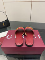 Women’s Gucci slide sandals in dark red leather, showing heel openings and strap