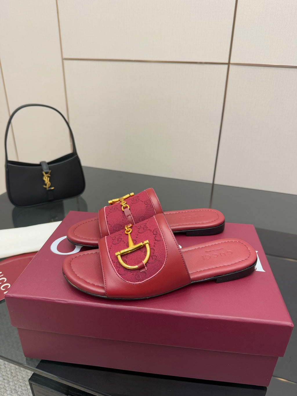 Women’s Gucci slide sandals in dark red leather with gold horsebit strap hardware