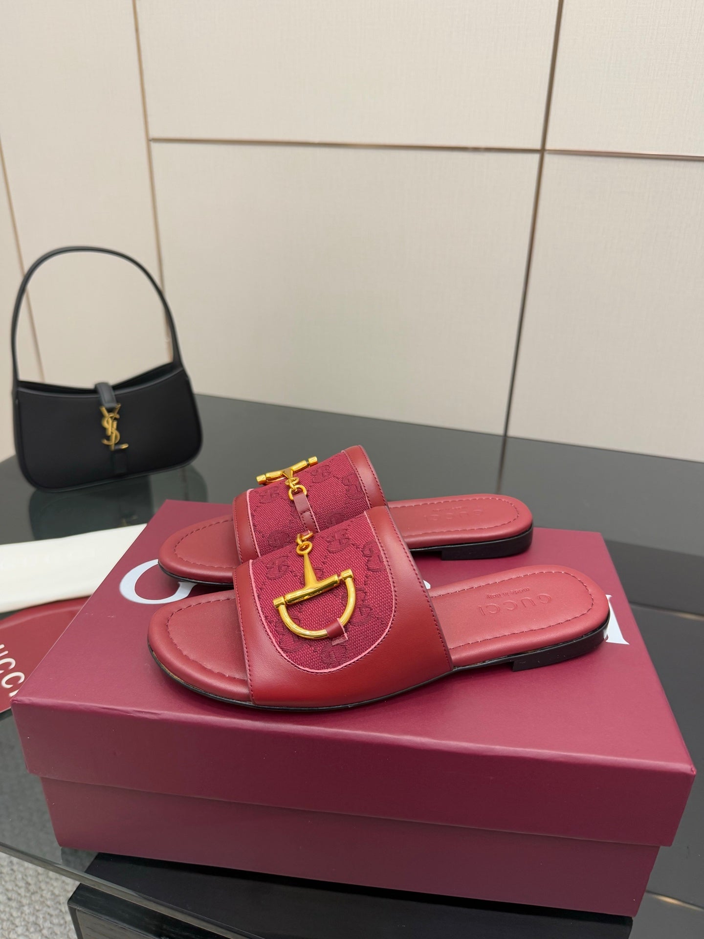 Women’s Gucci slide sandals in dark red leather with gold horsebit strap hardware