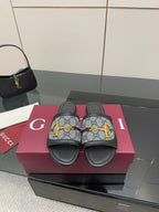Gucci ladies slide sandals with gray GG canvas straps, black leather, yellow hardware