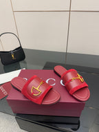 Pair of women's Gucci red slide sandals with gold-toned horsebit buckle strap