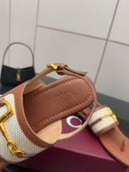 Tan thong sandals with white striped strap and gold buckle, Gucci insole close-up