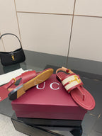 Red leather slide sandals with gold logo buckle and slingback strap