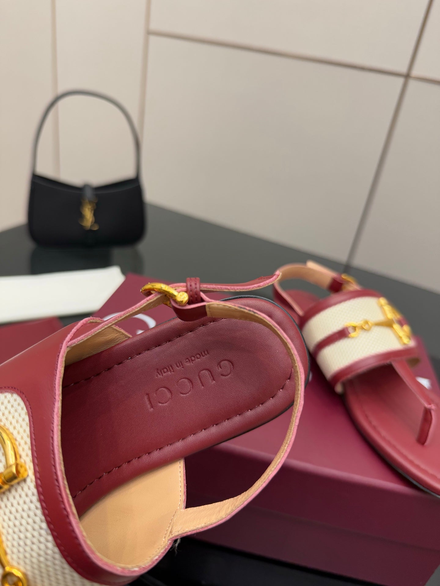 Red slide sandal with gold buckle and logo-printed interior strap detail