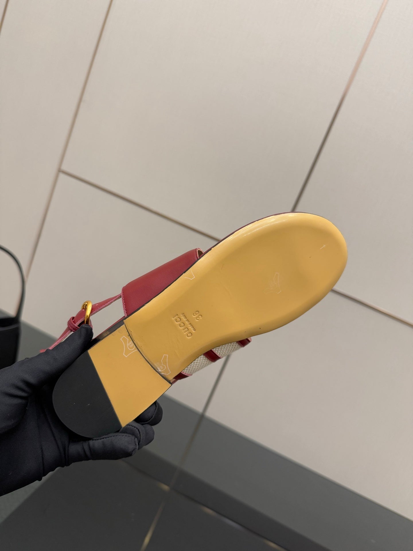 Red slide sandal outsole shown with tan rubber sole and gold buckle strap
