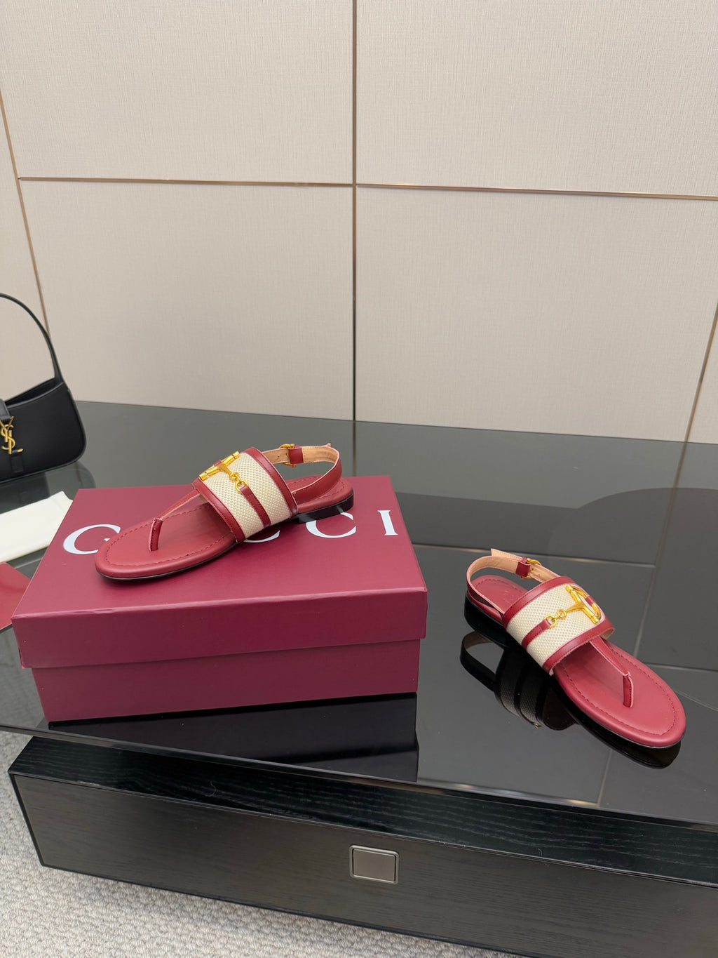Red thong sandals with gold buckle on patterned strap and open toe