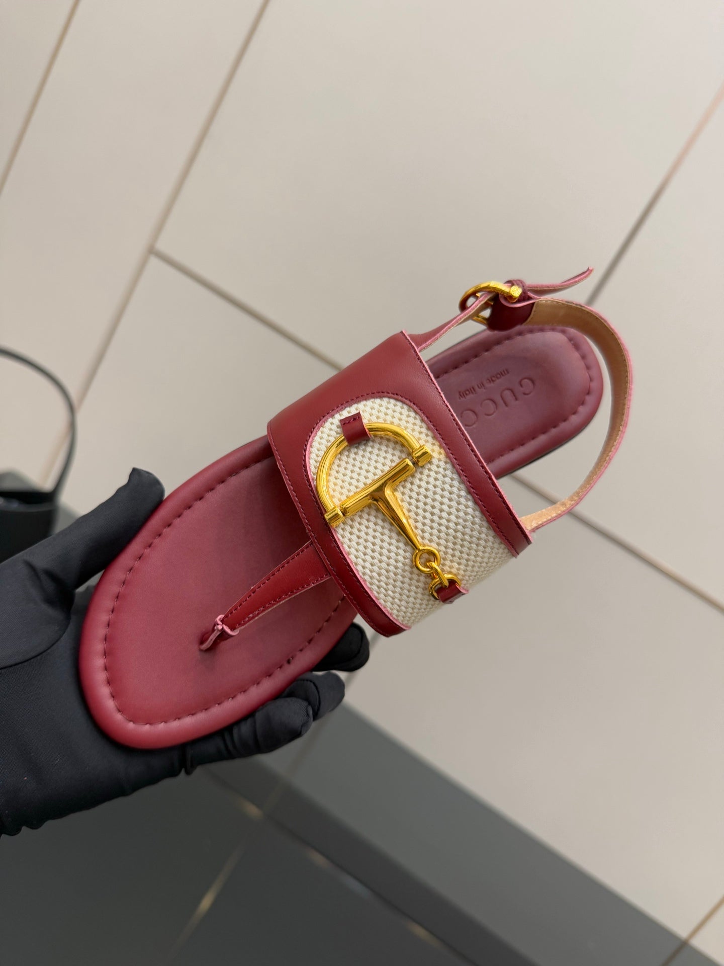 Red slide sandal with gold buckle on patterned strap and printed footbed