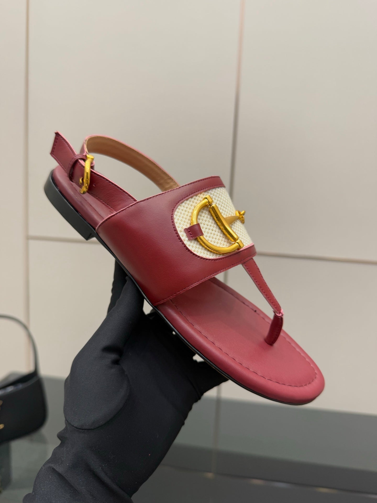 Red leather thong sandal with gold buckle and patterned cross strap