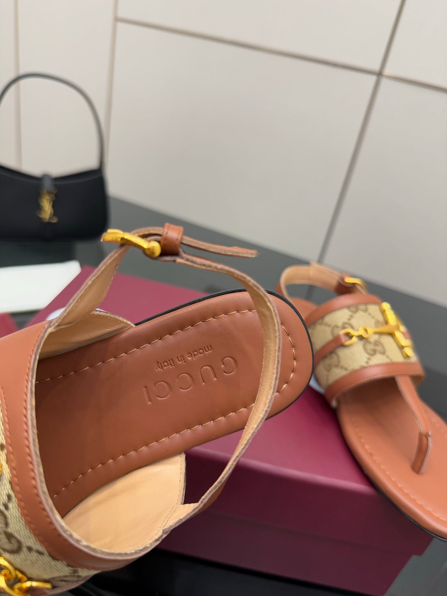Gucci thong sandal close-up, tan leather-look interior with logo stamp and strap