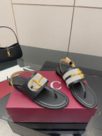 Ladies slide sandals pair: black thong sole with white check strap and gold buckle