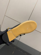 Ladies slide sandal outsole view: yellow rubber sole with printed stamp and gold buckle strap