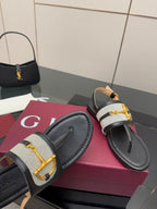 Ladies slide sandals close-up: black upper with white check inset and gold G buckle