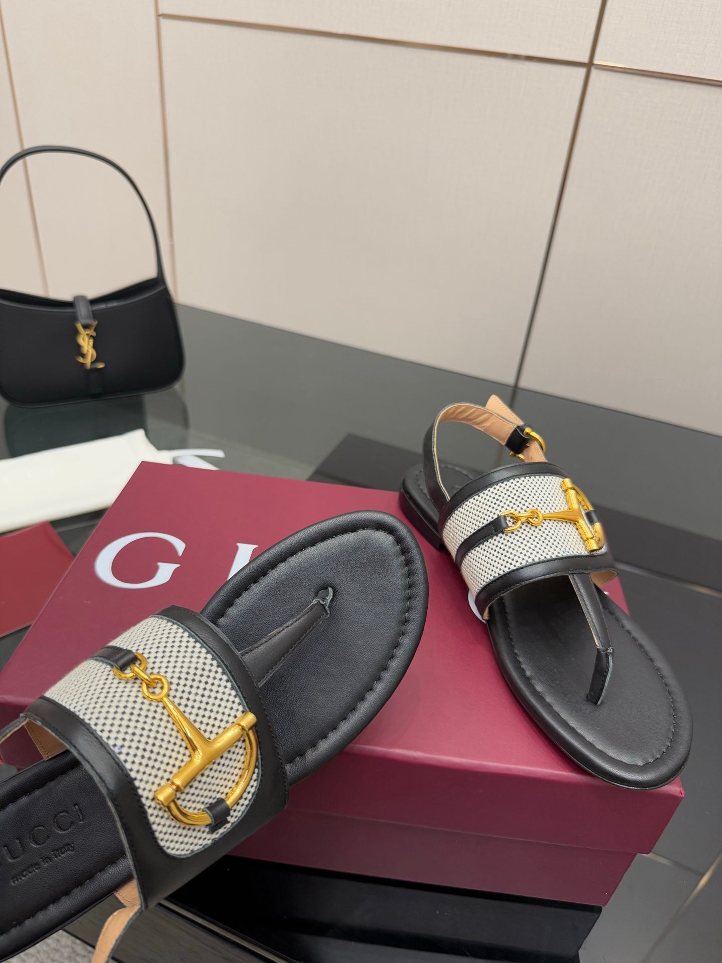 Ladies slide sandals close-up: black upper with white check inset and gold G buckle