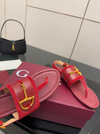 Gucci red slide sandals showing gold-tone horsebit detail on strap