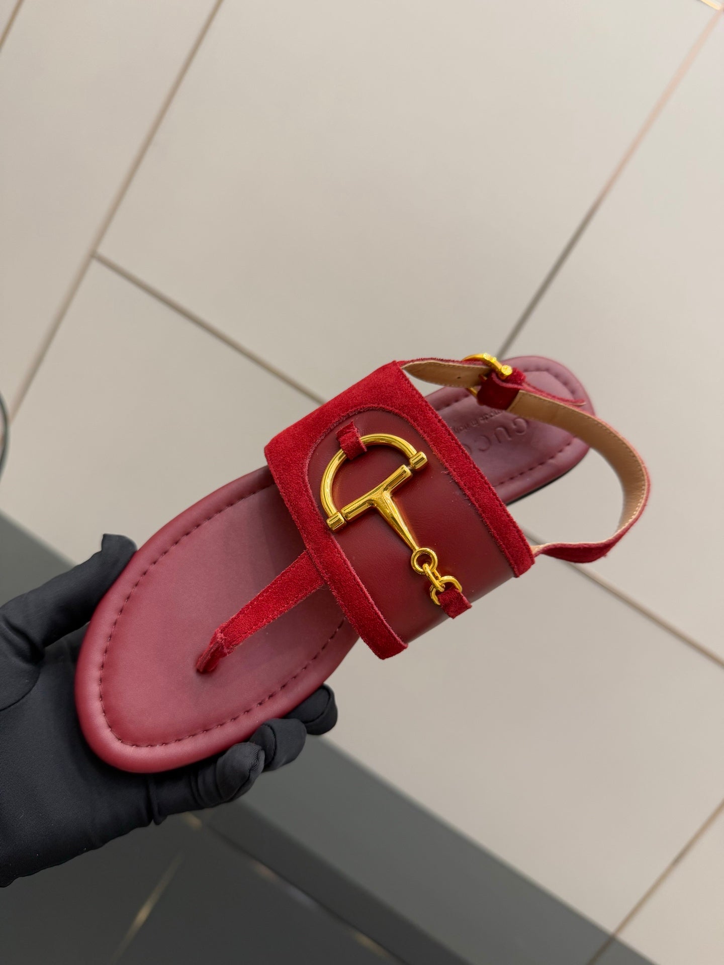 Gucci red flat sandals close-up of gold buckle strap