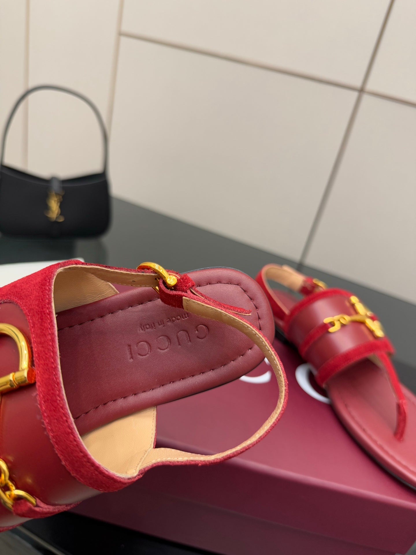 Gucci red sandals close-up of thong strap and gold-tone buckle
