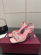 Pink heeled sandals with open toe, ankle strap, and jeweled buckle detail