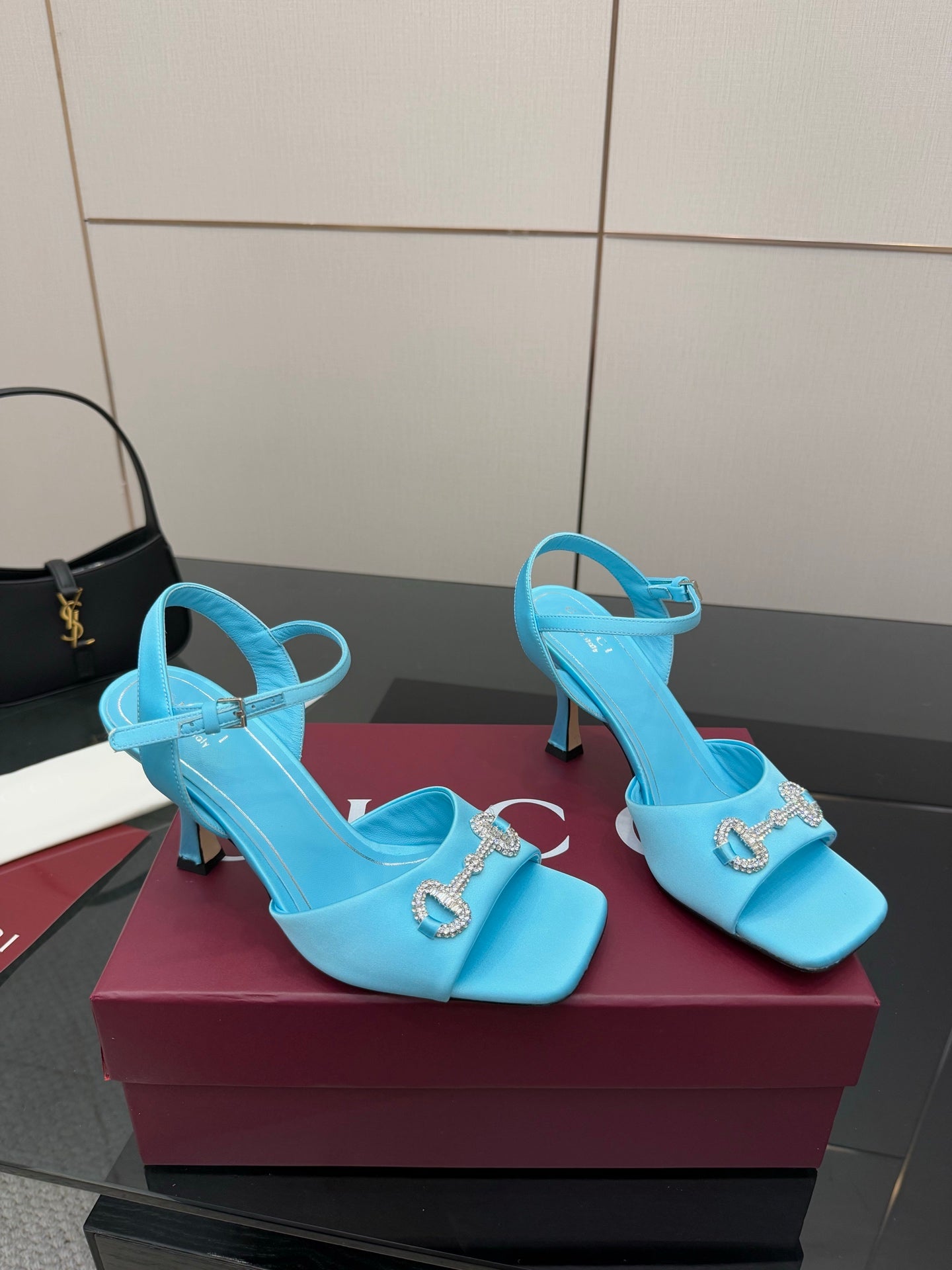 Light blue ladies heeled sandals with jeweled buckle detail and ankle strap.