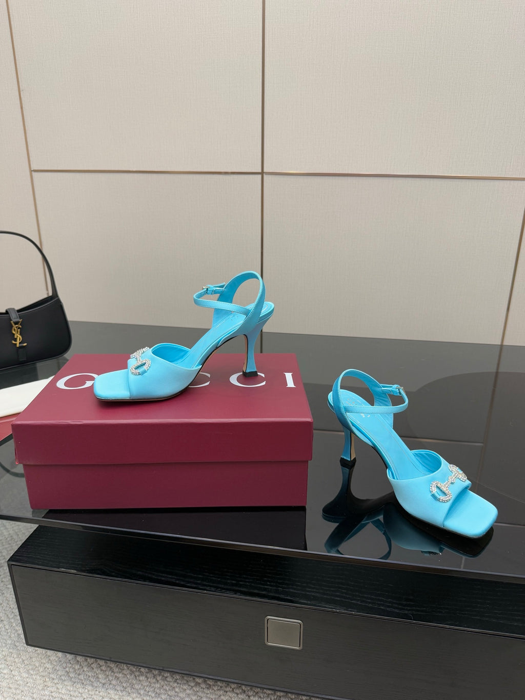 Light blue ladies heeled sandals with jeweled buckle and slim high heel, open toe.
