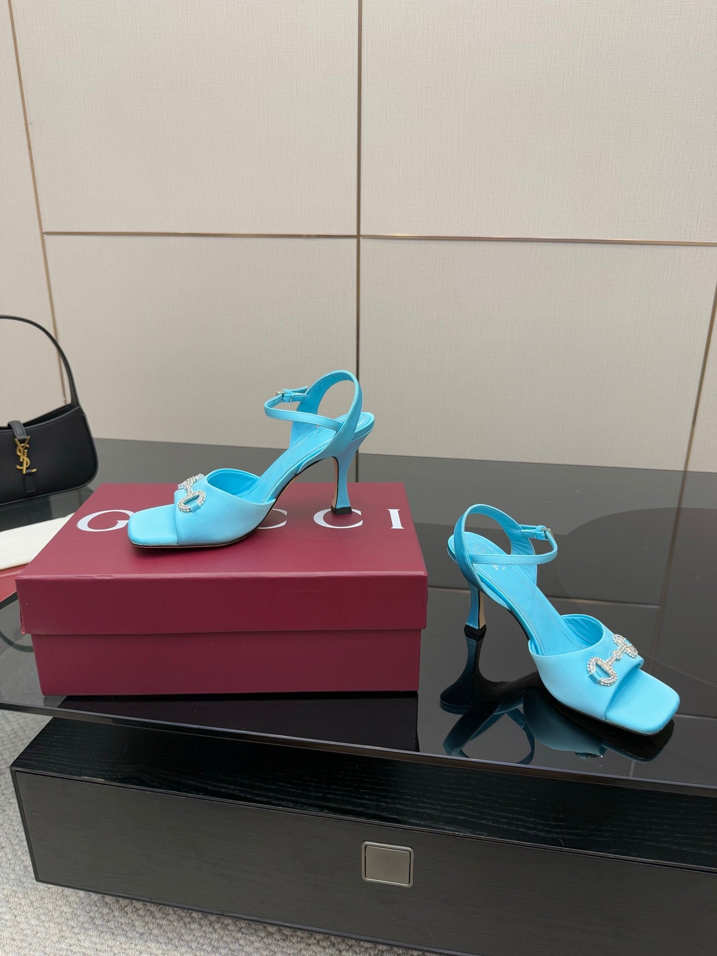 Light blue ladies heeled sandals with jeweled buckle and slim high heel, open toe.