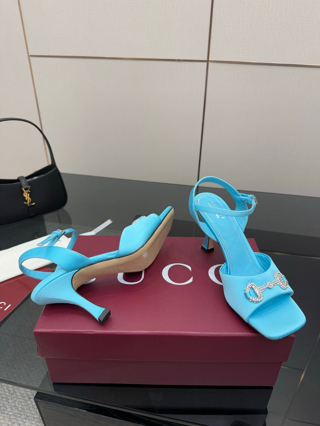 Light blue ladies heeled sandals with jeweled buckle ornament on the strap.