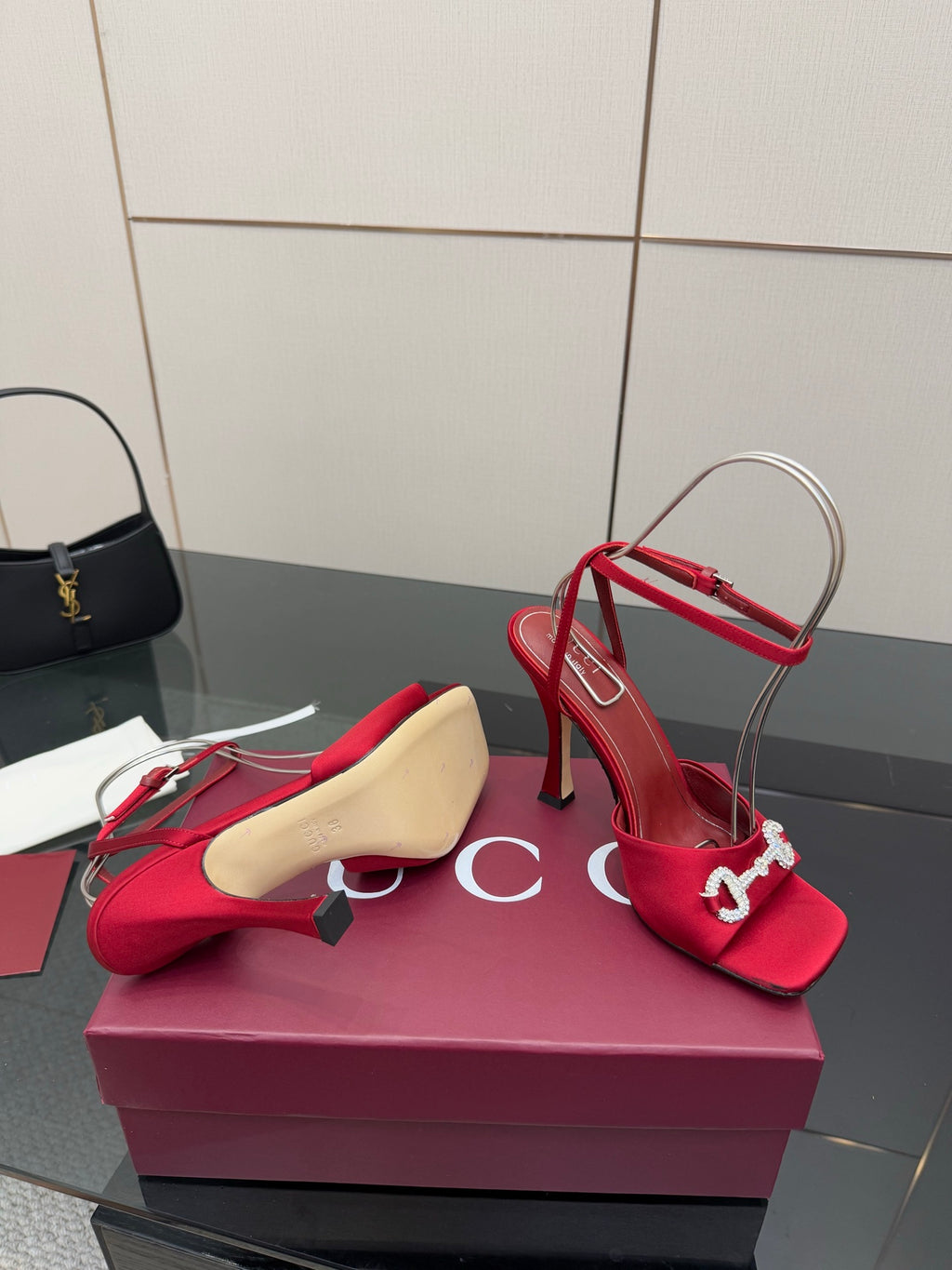 Red heeled sandals with silver buckle detail and thin straps, displayed with spare sole