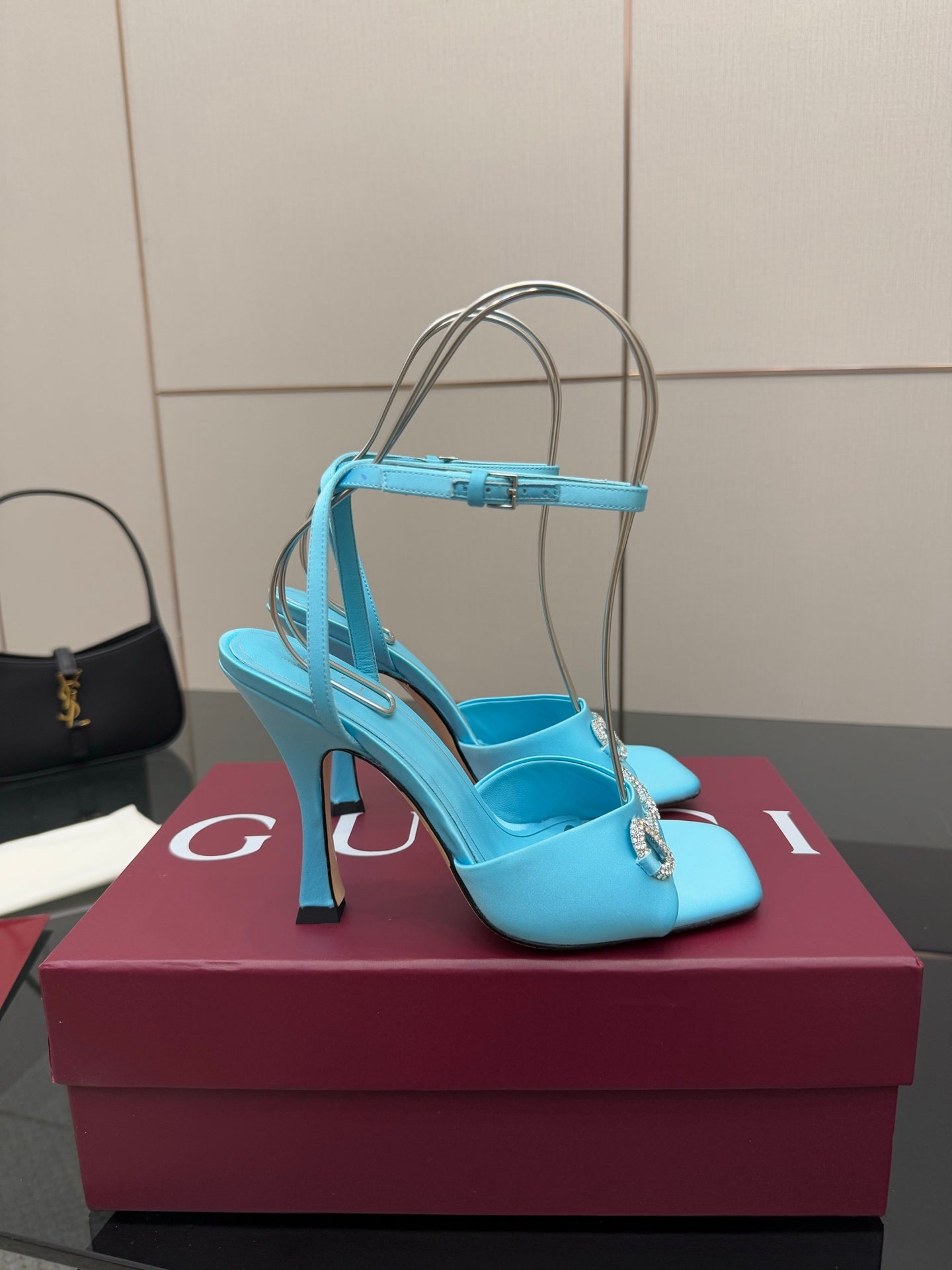 Women’s sky-blue heeled sandals with open toe, ankle strap, and gold-tone decorative detail