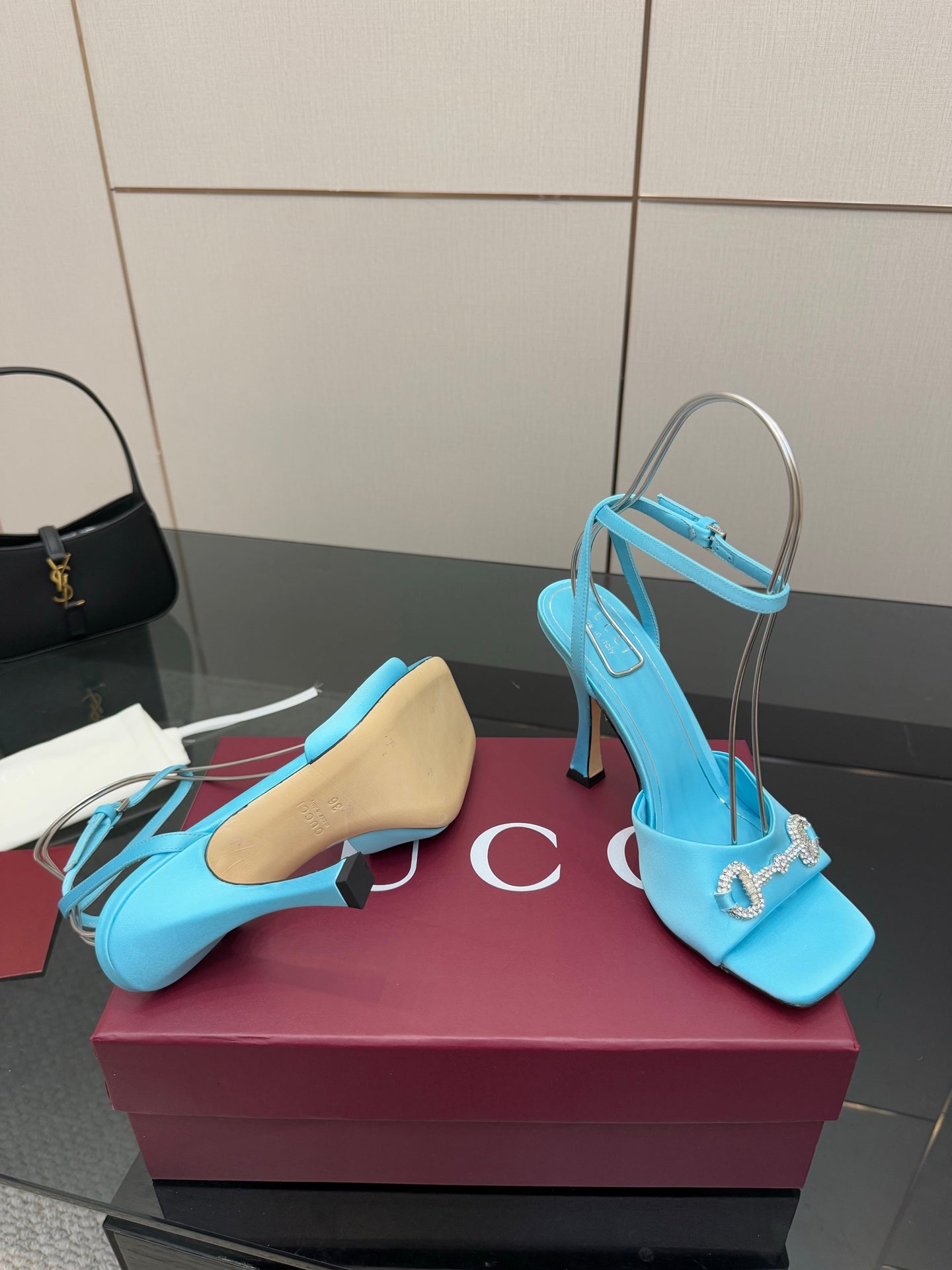 Women’s sky-blue heeled sandals with open toe, ankle strap, and gold-tone hardware