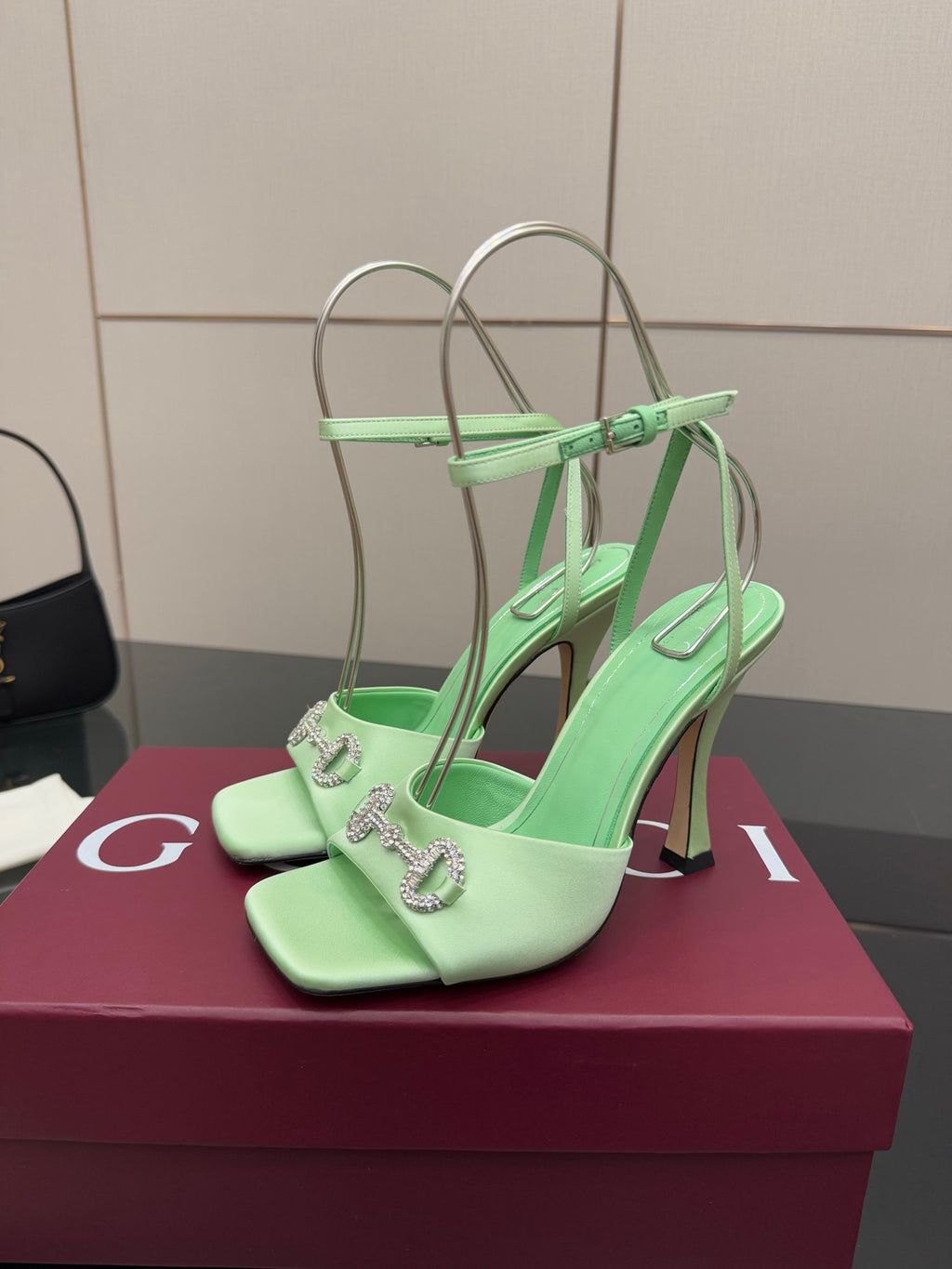 Green open-toe heeled sandals with silver chain-like hardware on straps