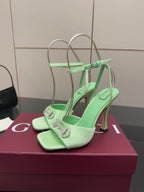Green open-toe heeled sandals with silver chain-like hardware on straps