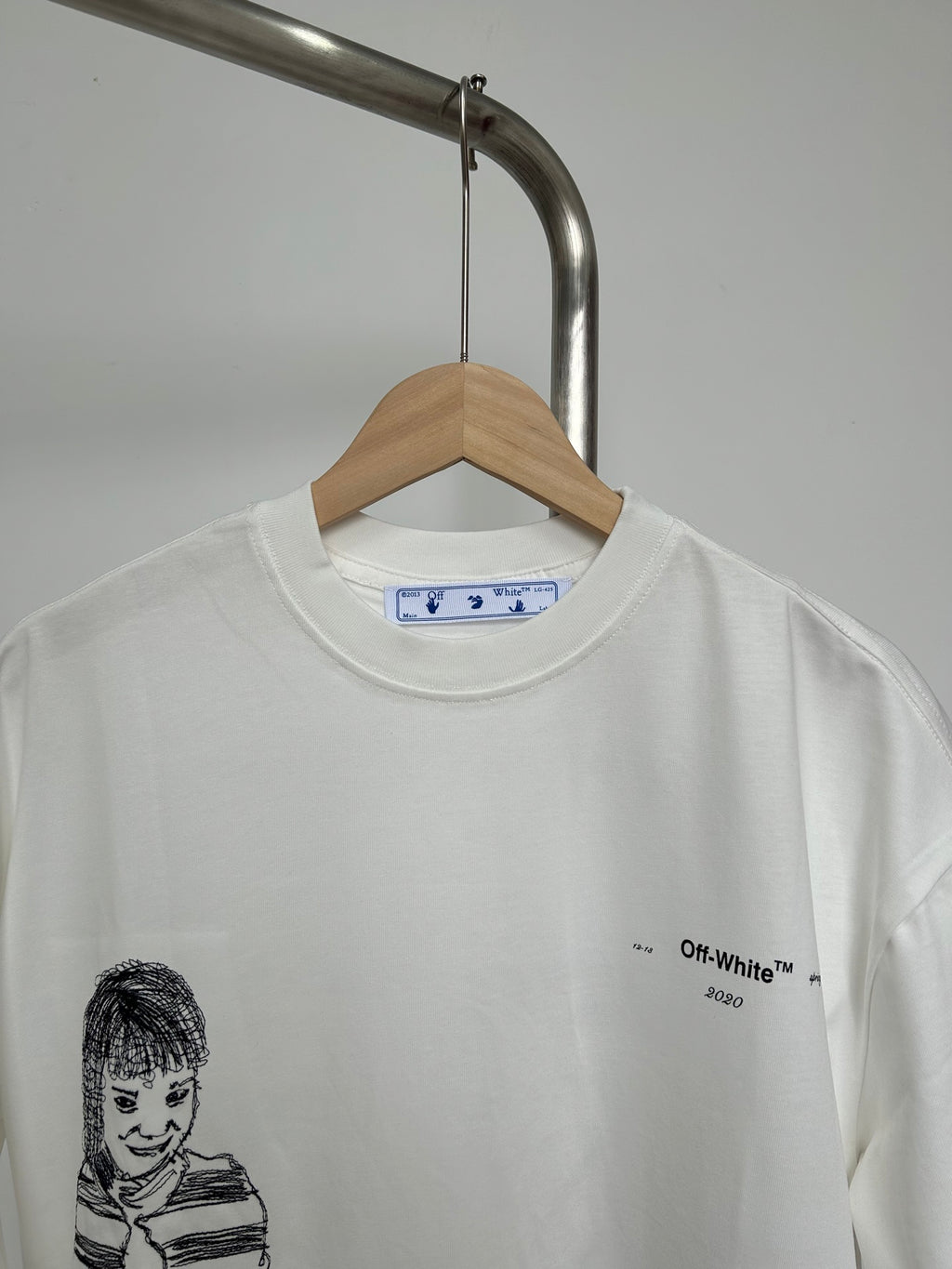 Off-white T-shirt with crew neck and black line portrait graphic at front