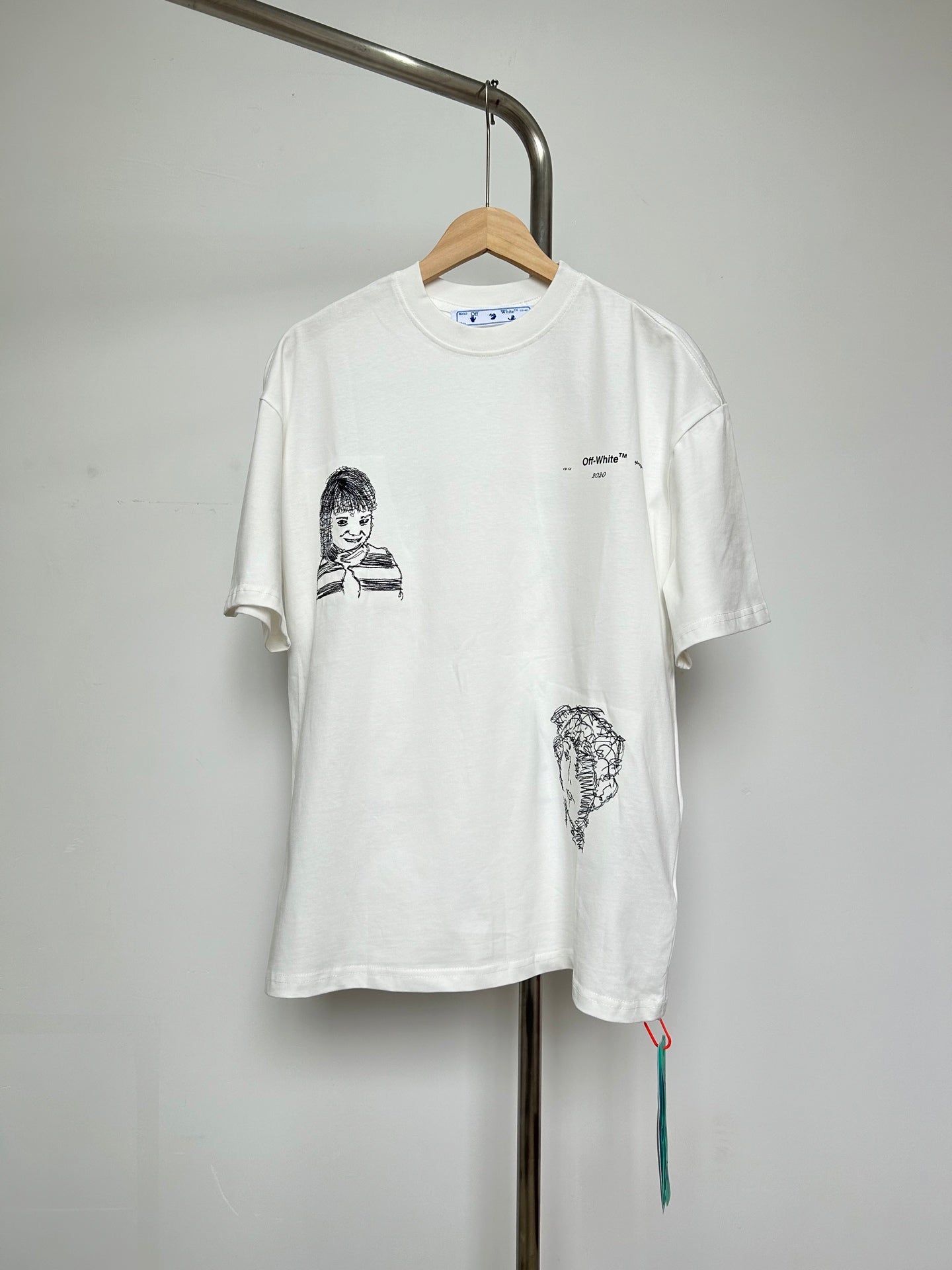 Off-white T-shirt with black line portrait graphic and small chest logo
