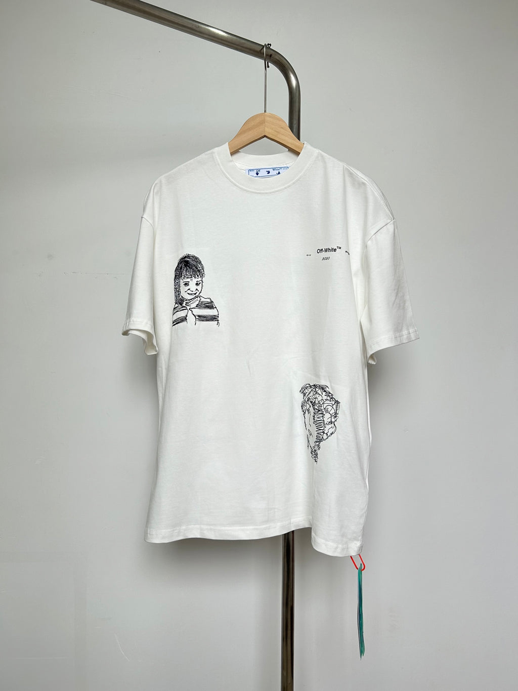 Off-white T-shirt with front cartoon graphic and small chest logo
