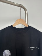 Black T-shirt close-up with small chest logo and white printed details