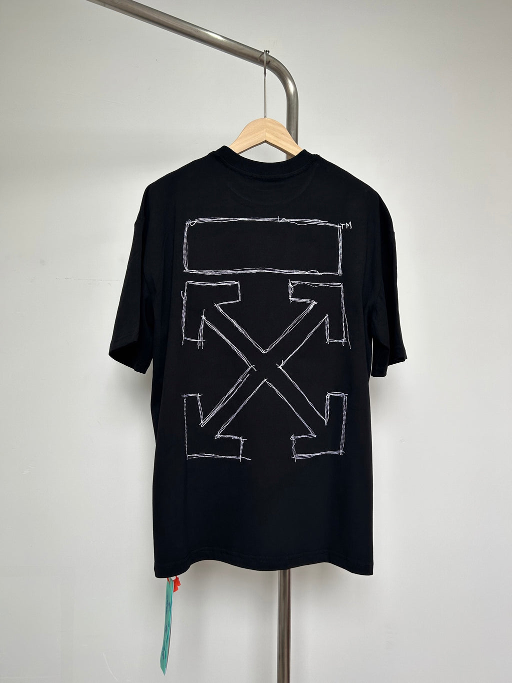 Black T-shirt with large white rectangular graphic and arrow X design