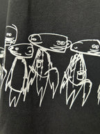 Black T-shirt detail with white outlined character heads and dripping line art