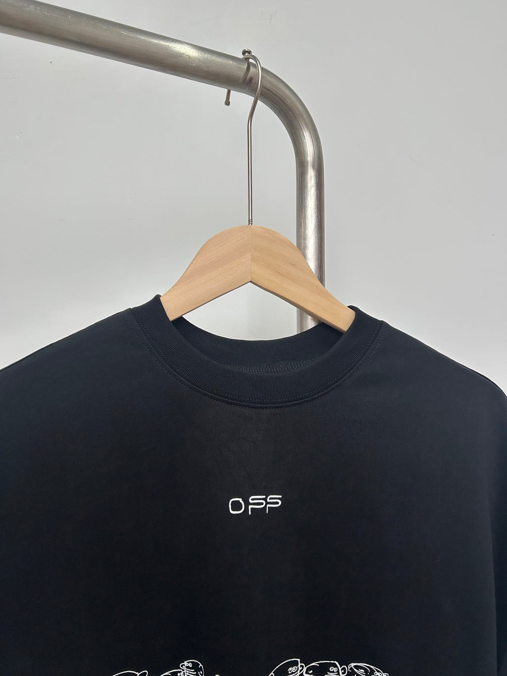 Black graphic T-shirt with small white O S S logo near the neckline