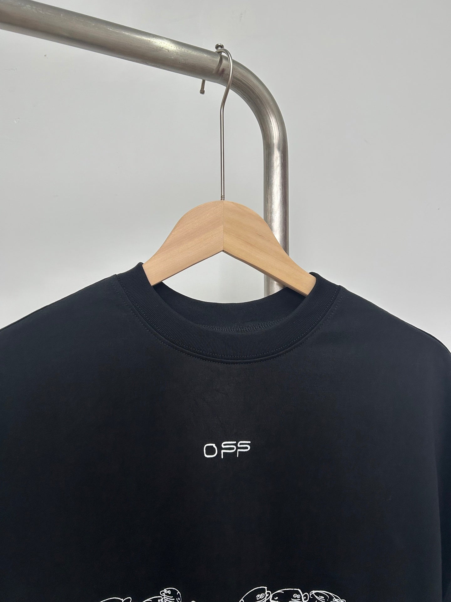 Black graphic T-shirt with small white O S S logo near the neckline
