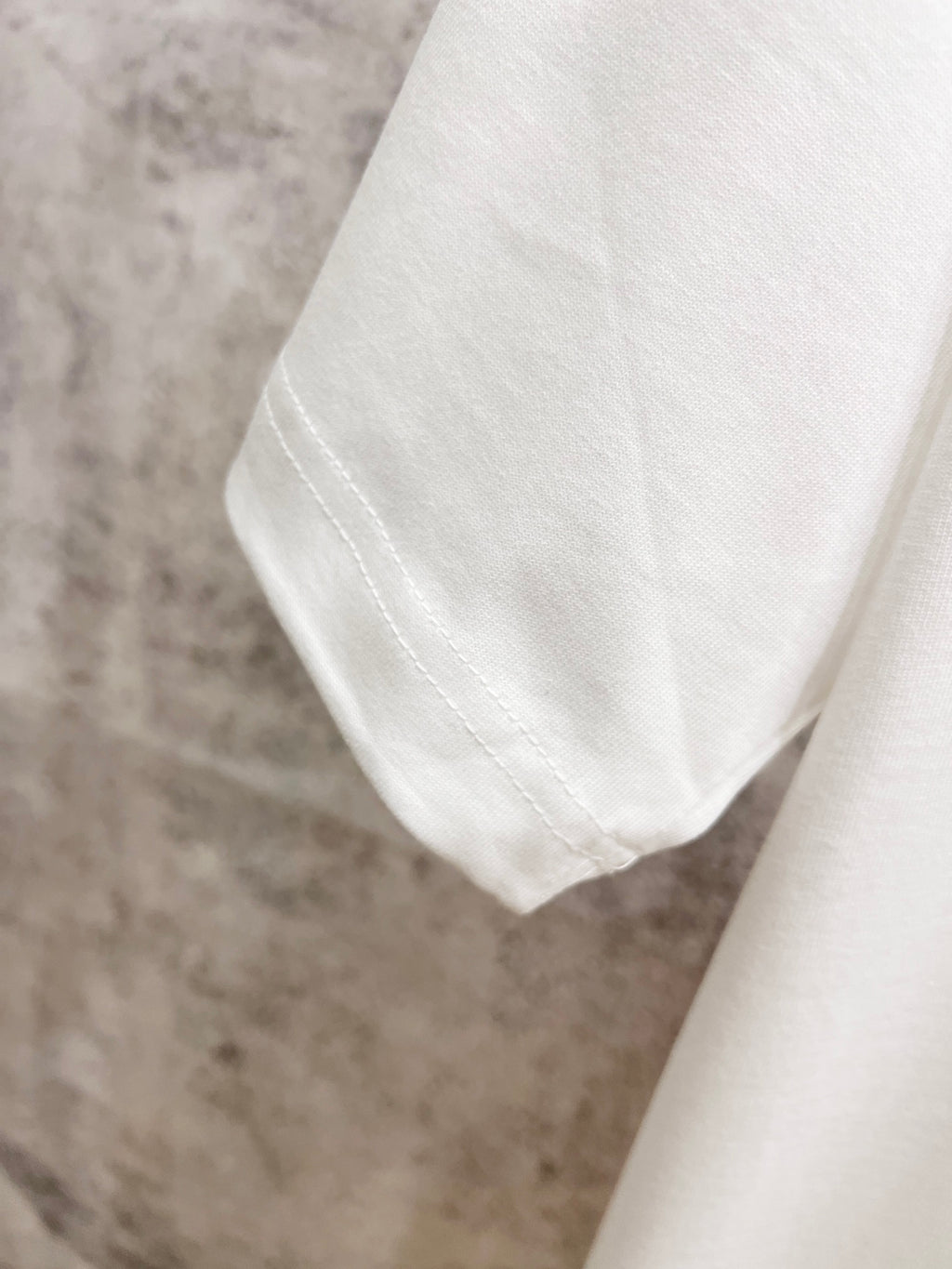 White T-shirt sleeve hem with visible seam stitching detail